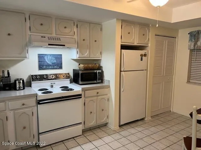 a kitchen with white cabinets and white appliances
