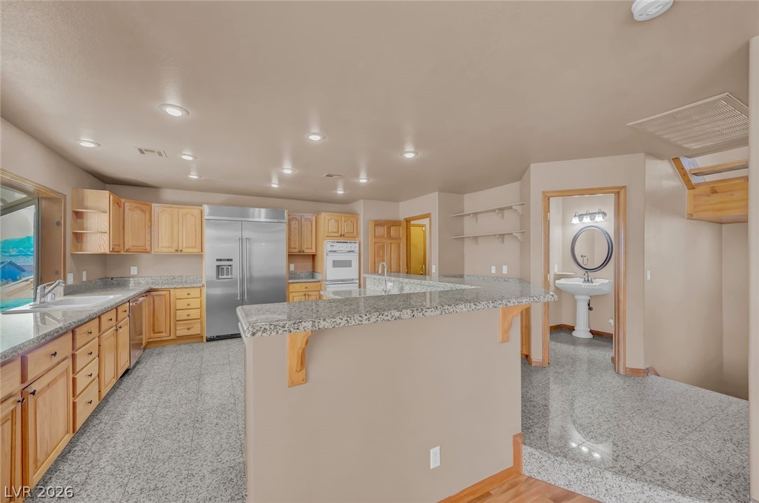 640 North Racetrack Road Henderson, NV 89015 - Photo 27 of 65 A well-equipped kitchen features ample counter space and a convenient breakfast bar, ideal for casual dining.