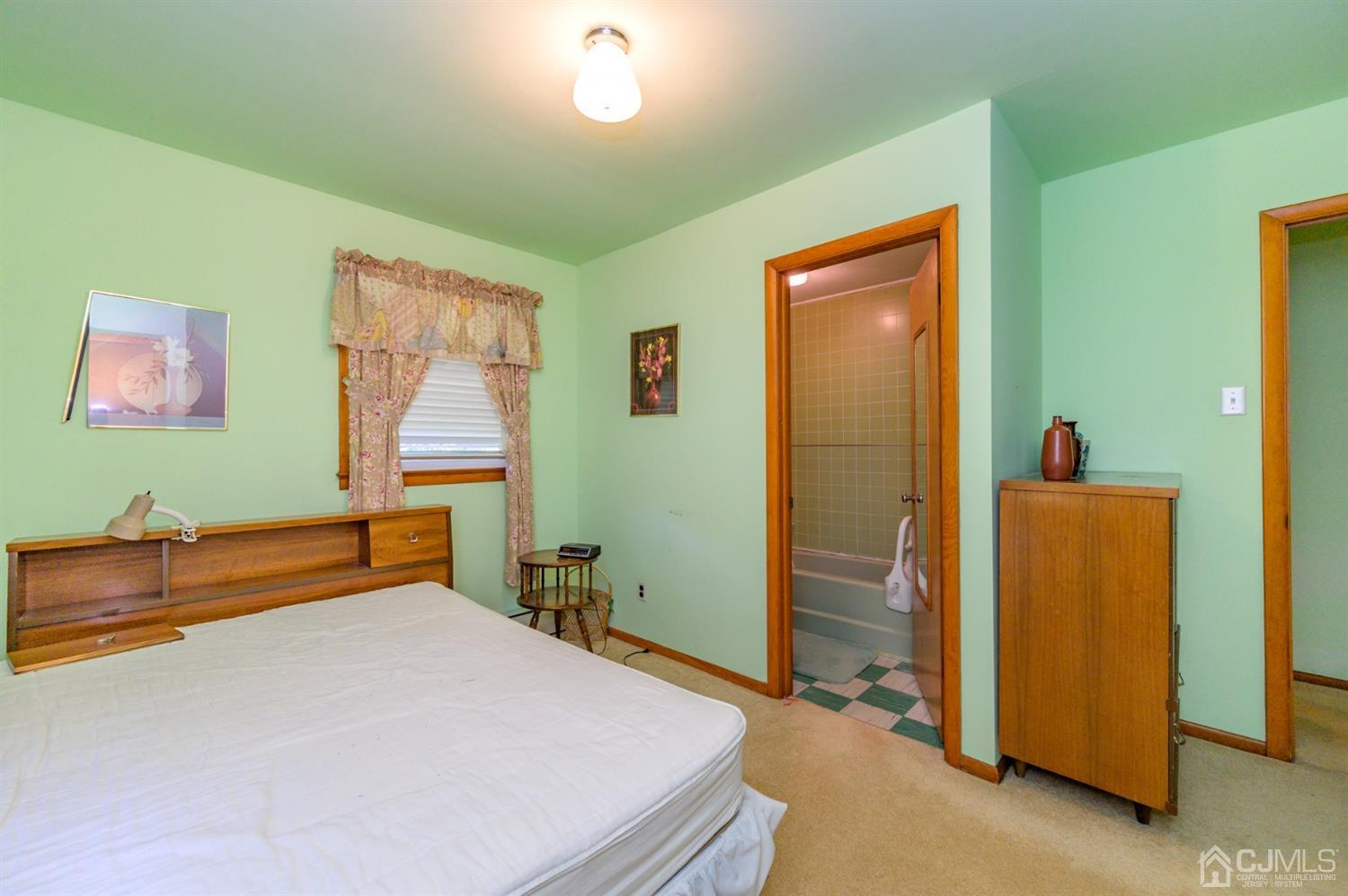 370 East Millstream Road Cream Ridge, NJ 08514 - Photo 33 of 54 a bedroom with a bed and a chandelier