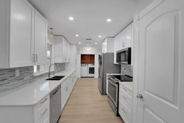 a kitchen with stainless steel appliances granite countertop a sink and stove top oven