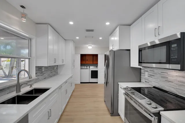 a kitchen with counter top space stainless steel appliances and cabinets