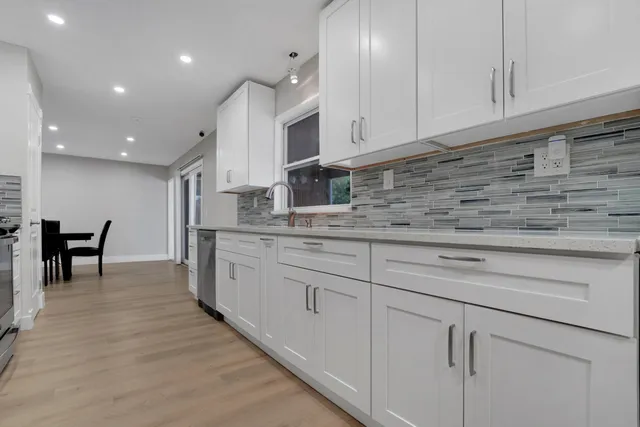 a kitchen with granite countertop white cabinets and a sink
