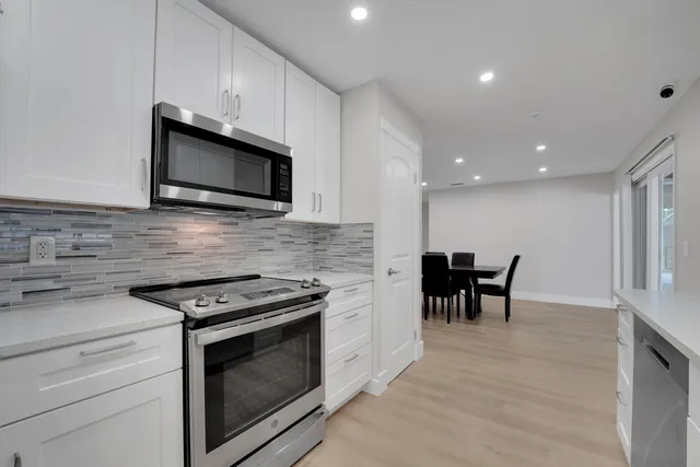 a kitchen with stainless steel appliances kitchen island granite countertop a sink and cabinets