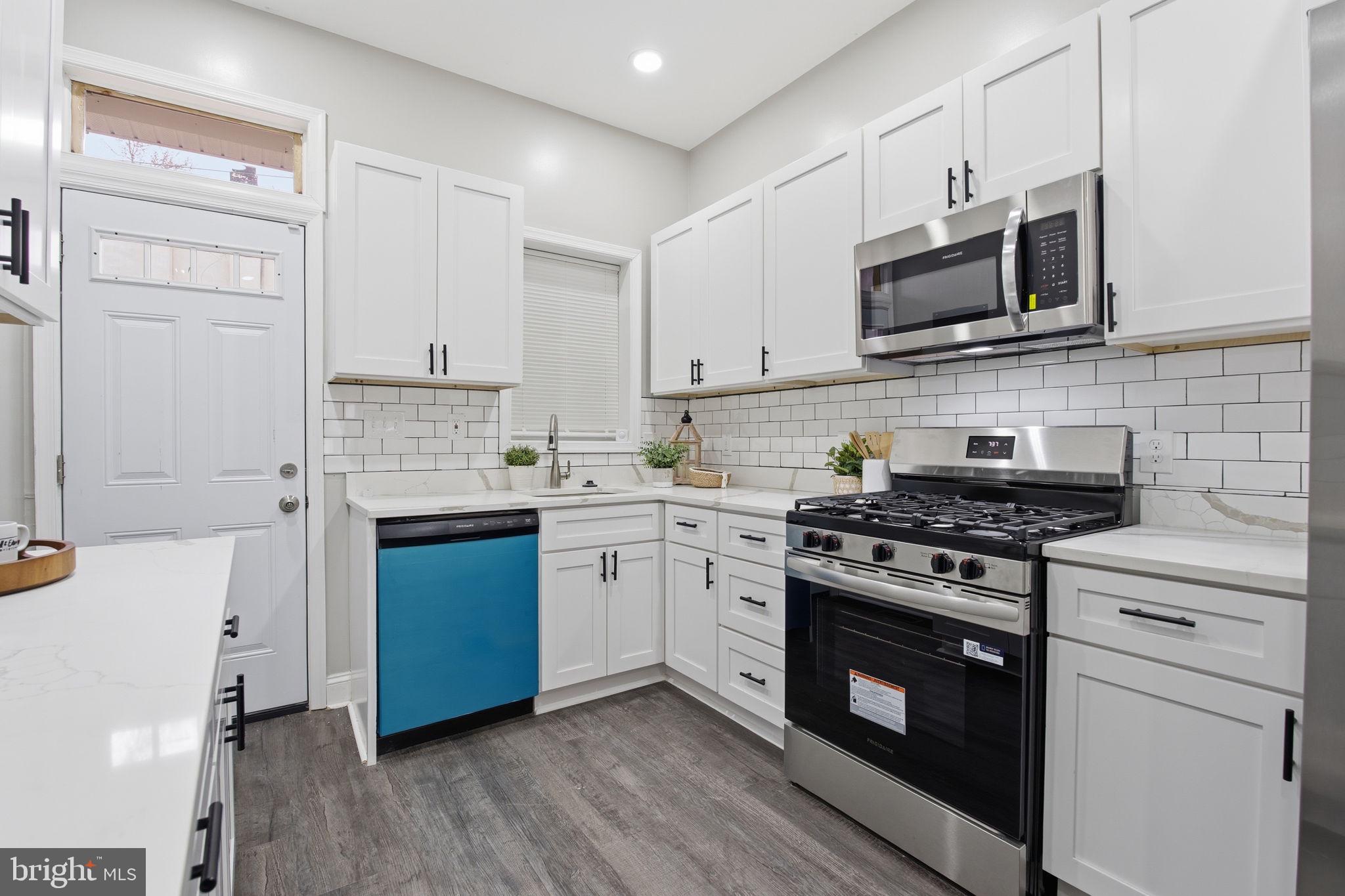 1708 Federal Street Baltimore, MD 21213 - Photo 11 of 33 a kitchen with stainless steel appliances a sink dishwasher a stove and a microwave oven with cabinets