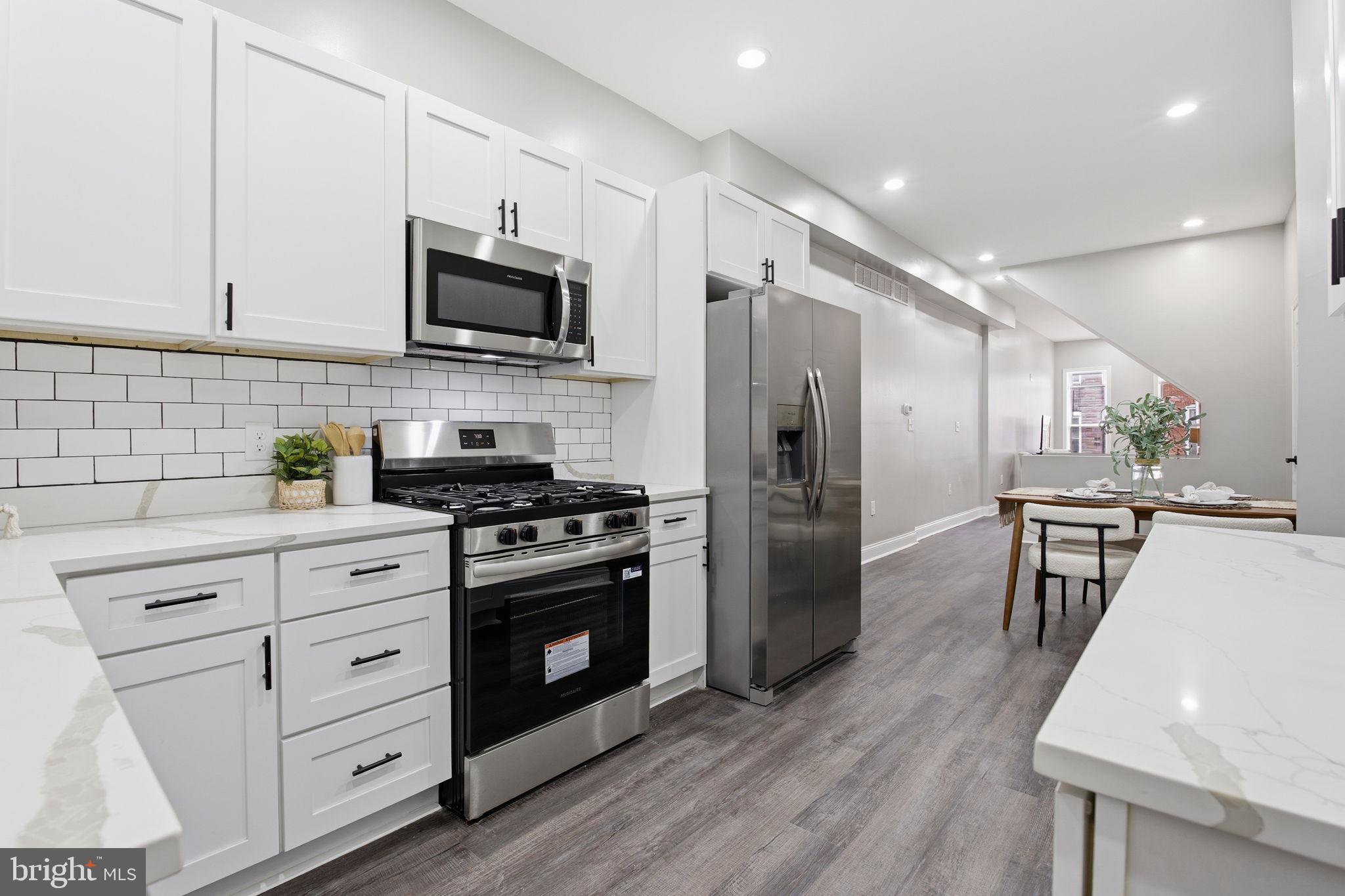 1708 Federal Street Baltimore, MD 21213 - Photo 13 of 33 a kitchen with stainless steel appliances a stove microwave and refrigerator