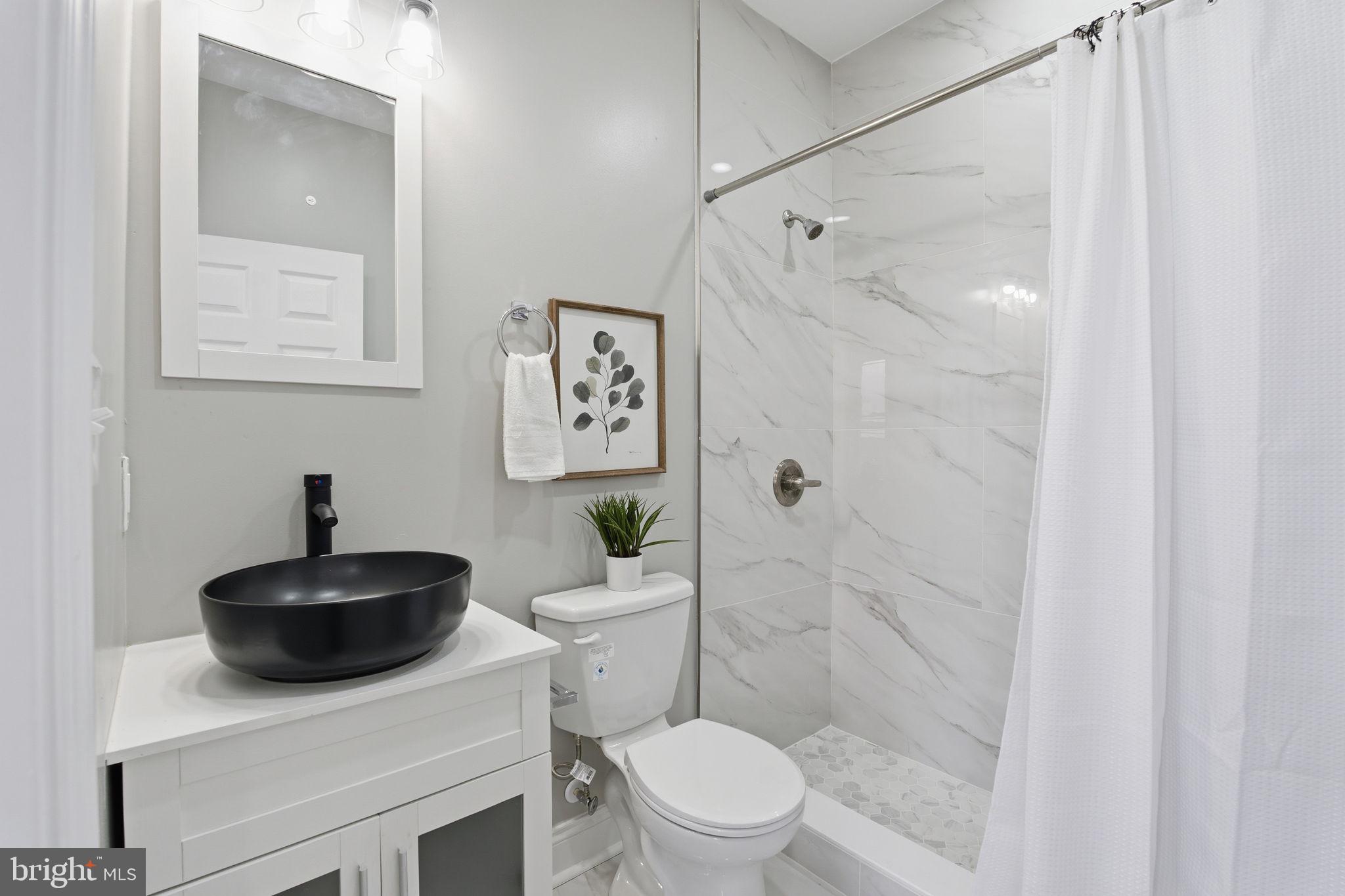 1708 Federal Street Baltimore, MD 21213 - Photo 18 of 33 a bathroom with a sink a toilet a mirror and shower