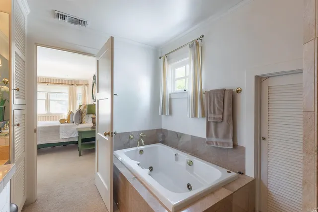 a bathroom with a tub sink and mirror