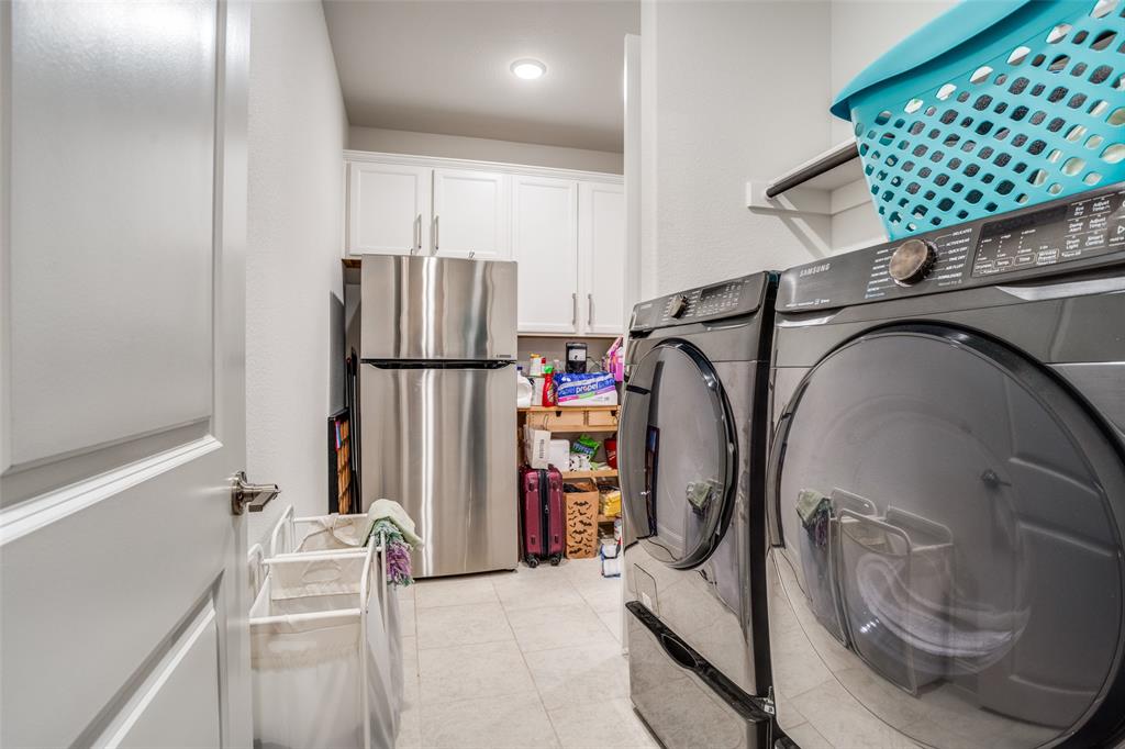 16380 Radstock Road Frisco, TX 75033 - Photo 12 of 39 Laundry area featuring cabinet space, washer and dryer, and light tile patterned flooring