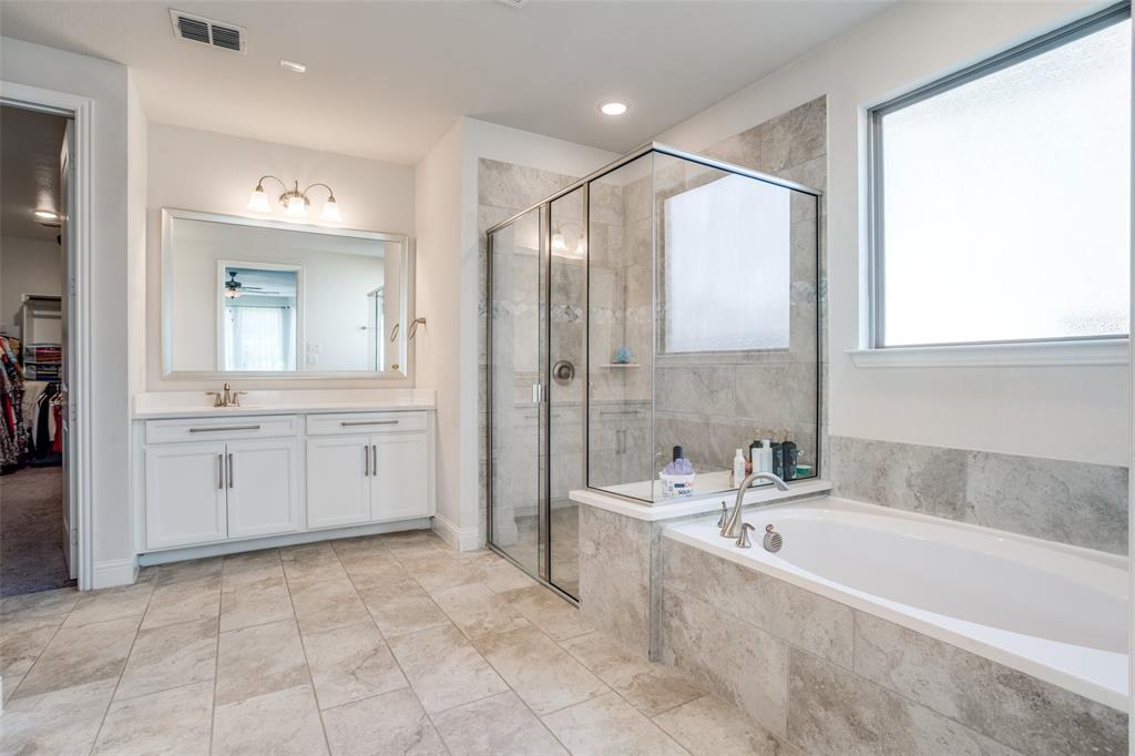 16380 Radstock Road Frisco, TX 75033 - Photo 28 of 39 Full bath featuring a walk in closet, vanity, a shower stall, and a bath