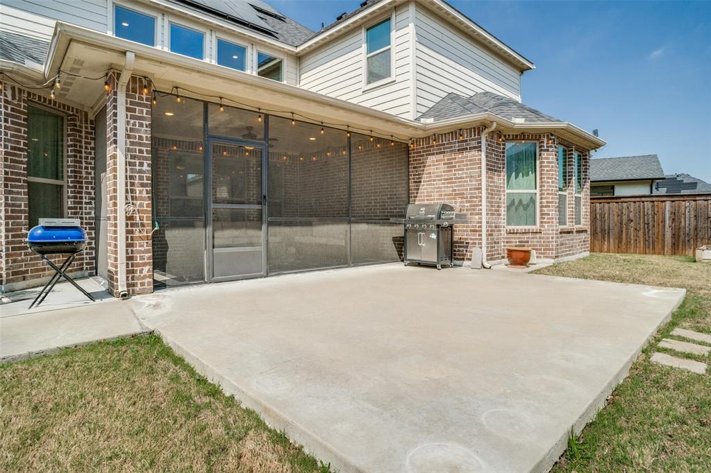 16380 Radstock Road Frisco, TX 75033 - Photo 31 of 39 Rear view of property featuring brick siding, a sunroom, a patio area, solar panels, and roof with shingles