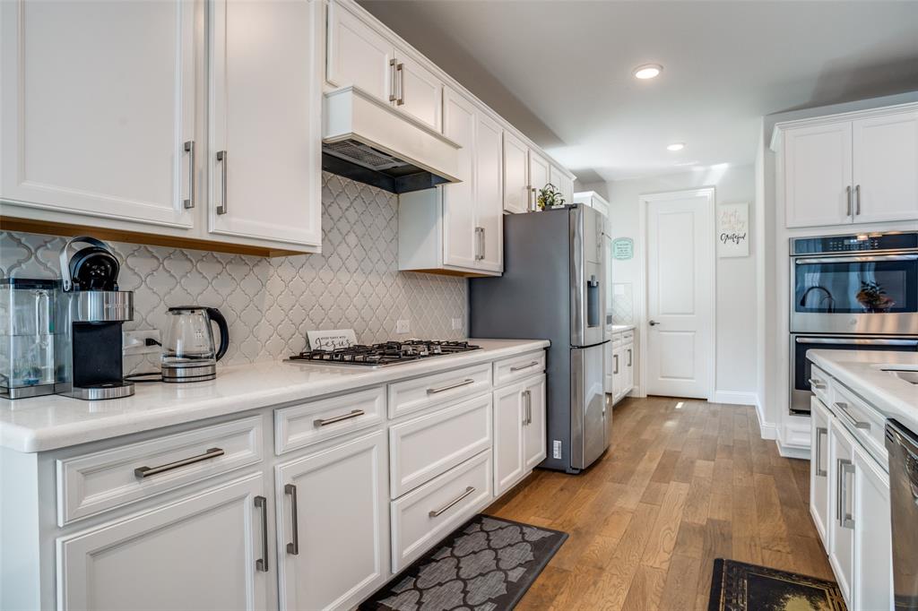 16380 Radstock Road Frisco, TX 75033 - Photo 8 of 39 Kitchen featuring white cabinets, stainless steel appliances, light wood-style flooring, recessed lighting, and backsplash
