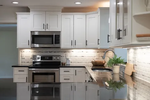 a spacious bathroom with a granite countertop sink a mirror and a shower