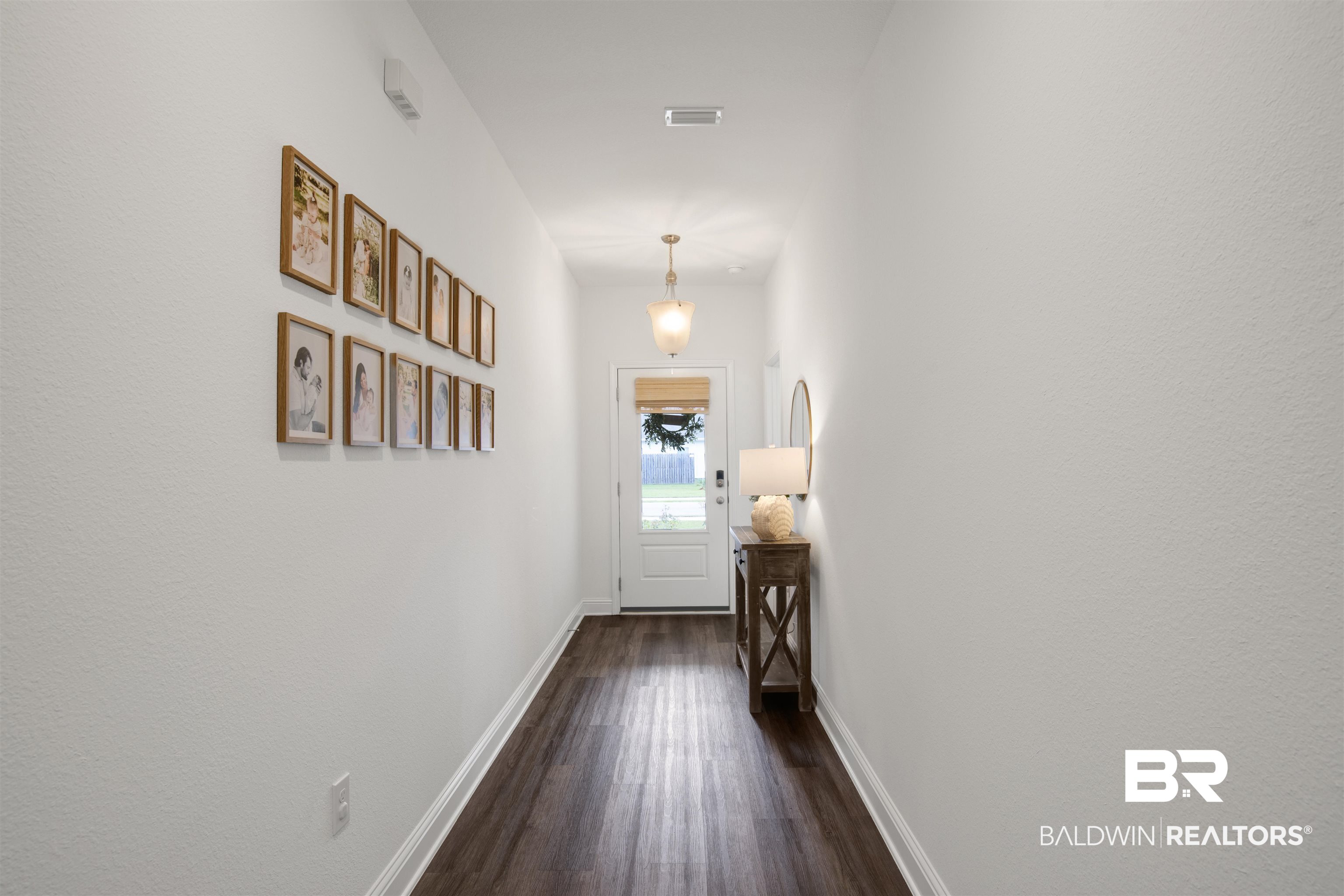 594 Shepard Street Gulf Shores, AL 36542 - Photo 2 of 51 Hallway featuring baseboards and dark wood finished floors