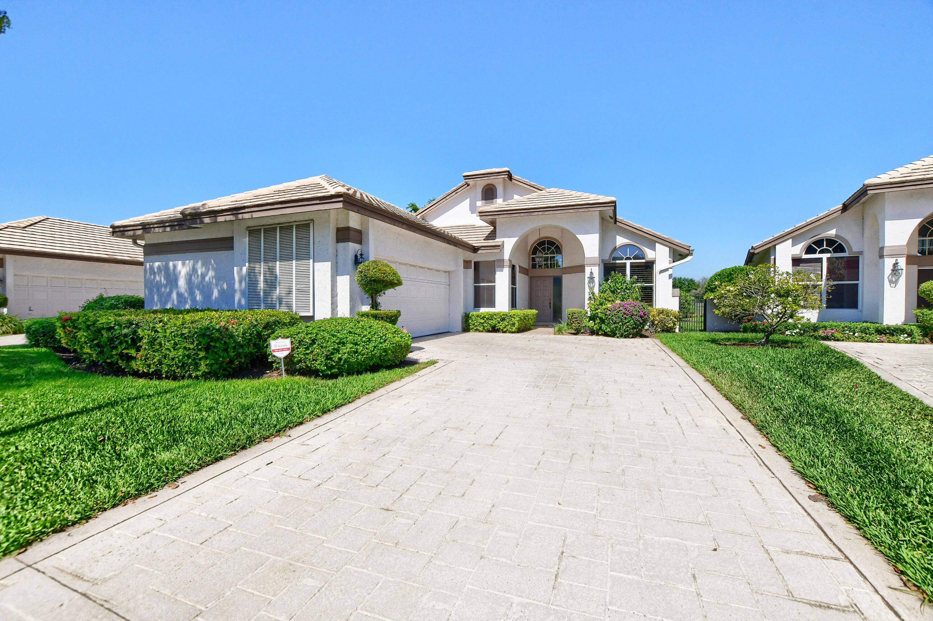 a front view of a house with a yard and potted plants