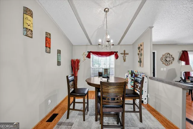 a view of a dining room with furniture and a chandelier
