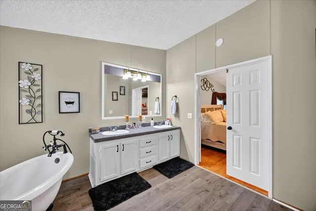 a en suite bathroom with a double vanity sink a mirror and a bathtub