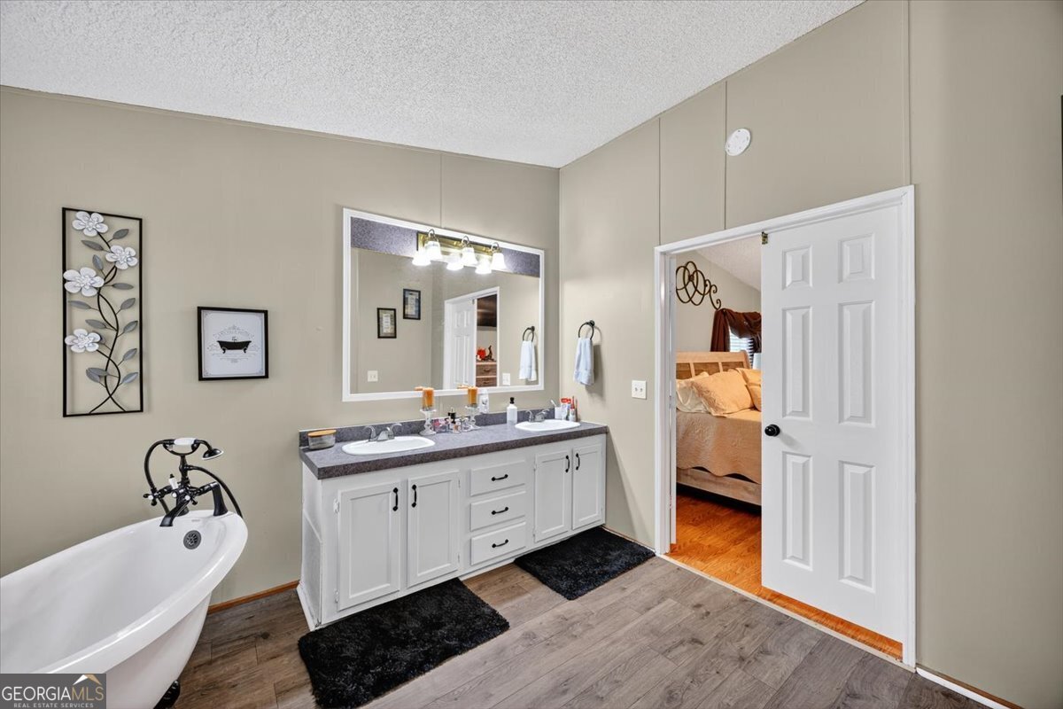 1659 Henderson Road Macon, GA 31217 - Photo 20 of 44 a en suite bathroom with a double vanity sink a mirror and a bathtub