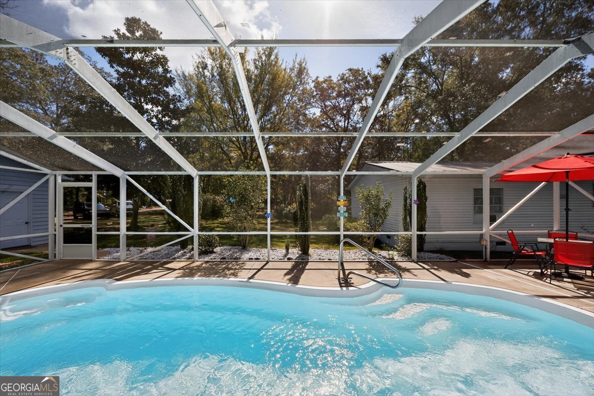1659 Henderson Road Macon, GA 31217 - Photo 30 of 44 a blue swimming pool with a yard and wooden fence