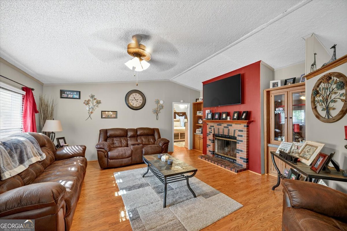 1659 Henderson Road Macon, GA 31217 - Photo 3 of 44 a living room with furniture a flat screen tv and a fireplace