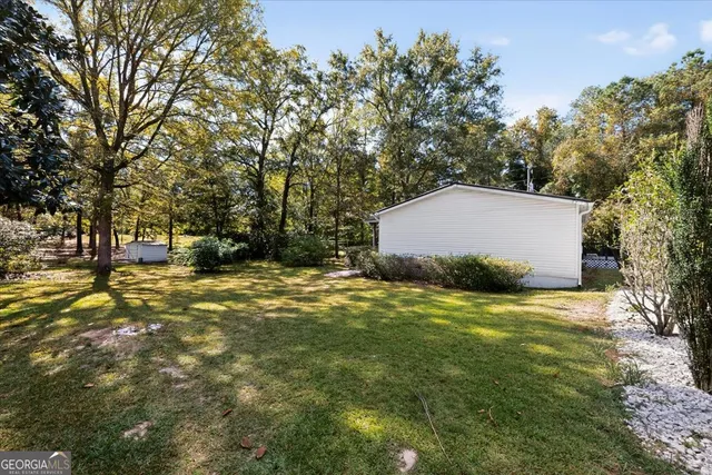 a view of a houses with yard and trees