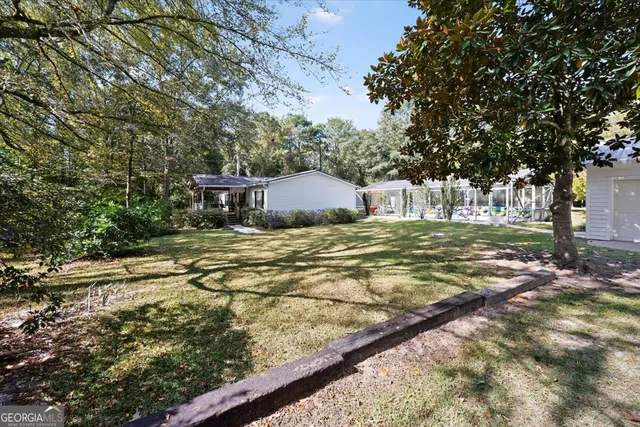 a backyard of a house with large trees and parked
