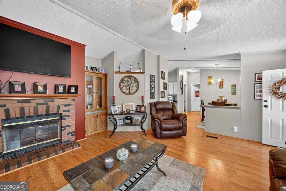1659 Henderson Road Macon, GA 31217 - Photo 5 of 44 a living room with furniture a flat screen tv and a fireplace