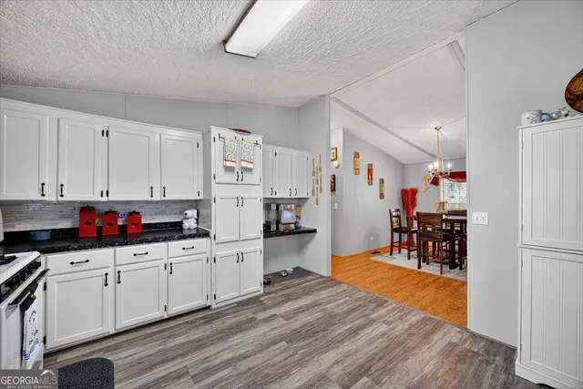 a kitchen that has a lot of cabinets a sink and appliances in it