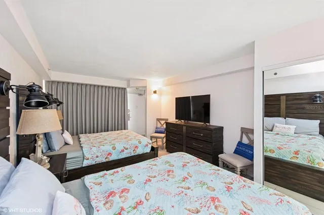 a bedroom with two bed and a television