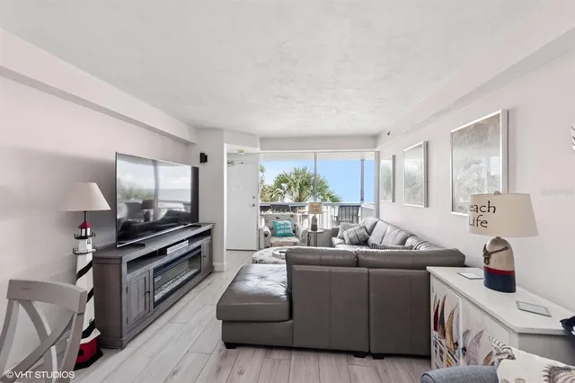 a living room with furniture a window and a flat screen tv