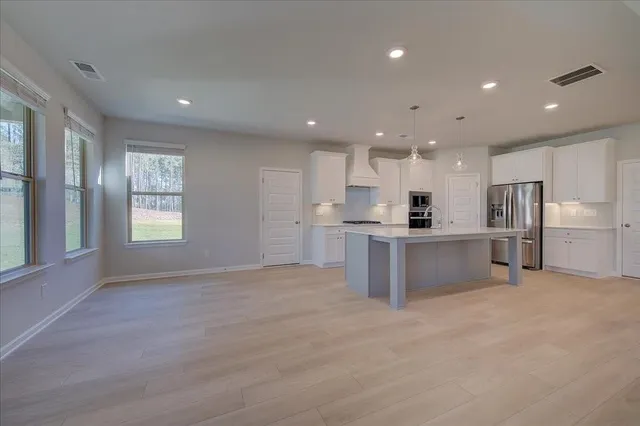 a view of kitchen with refrigerator and windows