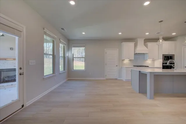 a view of kitchen with granite countertop stainless steel appliances refrigerator sink and cabinets