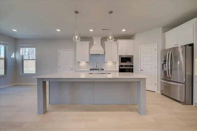 a kitchen with stainless steel appliances granite countertop a refrigerator and a sink