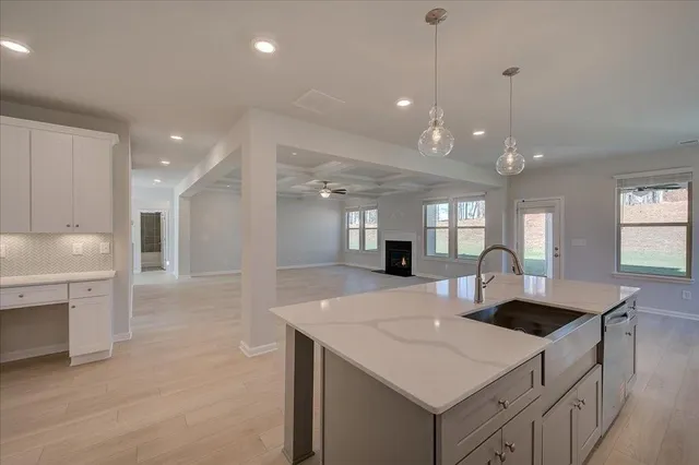 a kitchen with center island a sink dishwasher a dining table and chairs with wooden floor