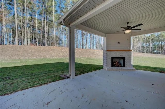 a view of a porch with a fireplace and a yard