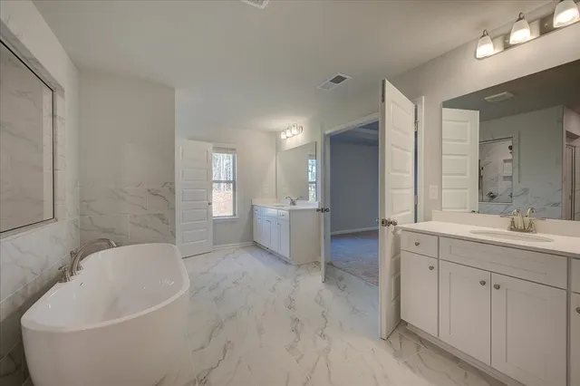 a spacious bathroom with a bathtub sink and toilet