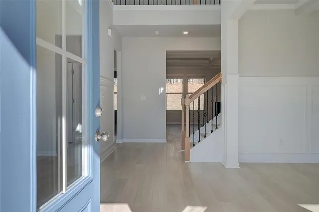 a view of a hallway with wooden floor and staircase