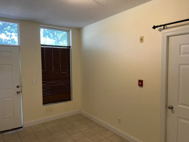 a view of empty room with window and hallway