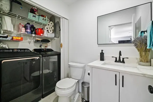 a bathroom with a toilet a sink and mirror
