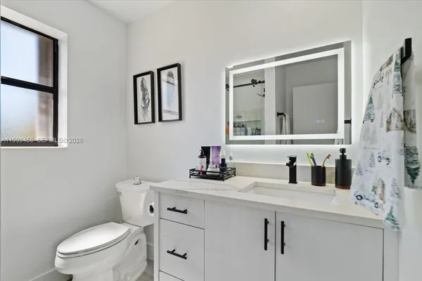 a bathroom with a toilet sink and mirror