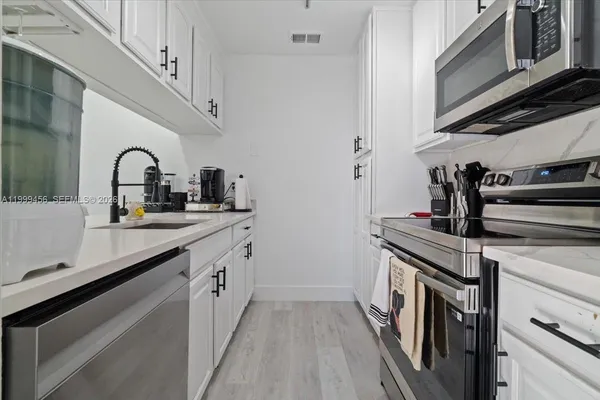 a kitchen with stainless steel appliances granite countertop a sink and cabinets