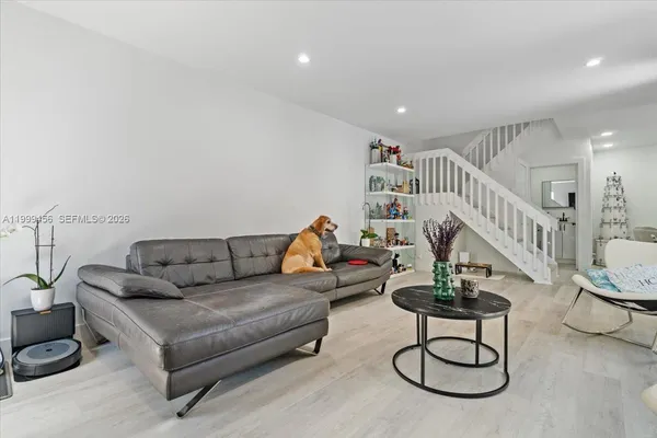 a living room with furniture a rug and white walls
