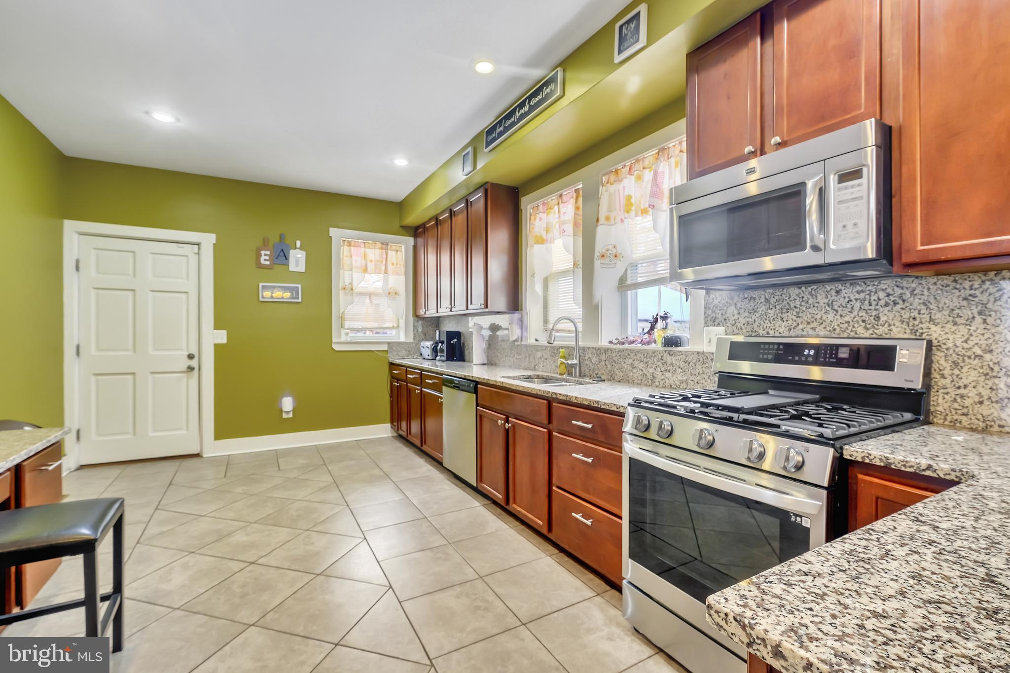 3504 Edgewood Road Baltimore, MD 21215 - Photo 15 of 60 a kitchen with stainless steel appliances granite countertop a stove a sink and a microwave