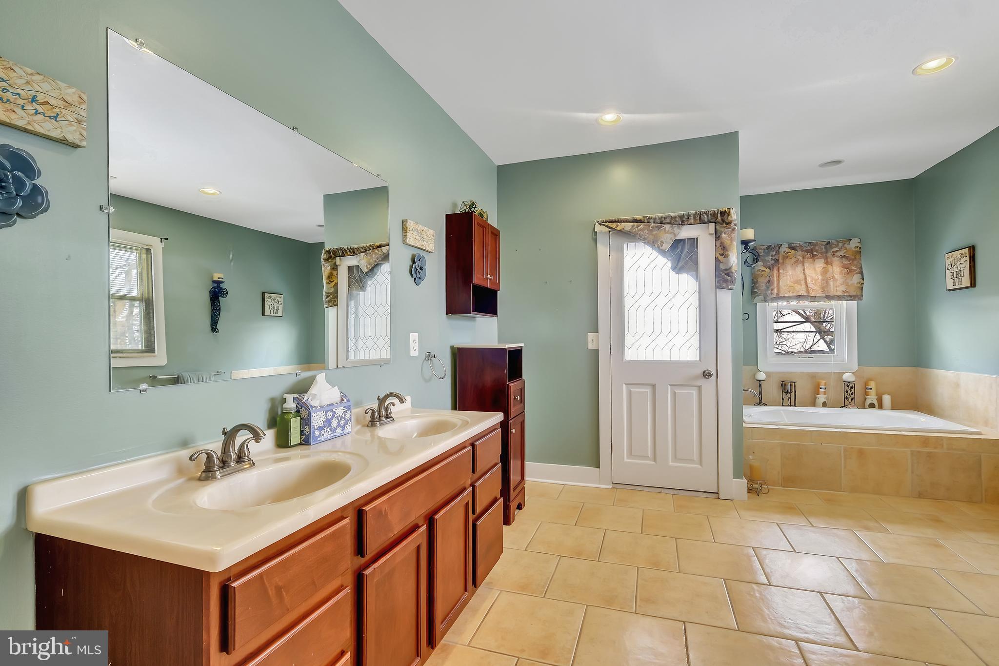 3504 Edgewood Road Baltimore, MD 21215 - Photo 31 of 60 a bathroom with a sink a tub and a mirror