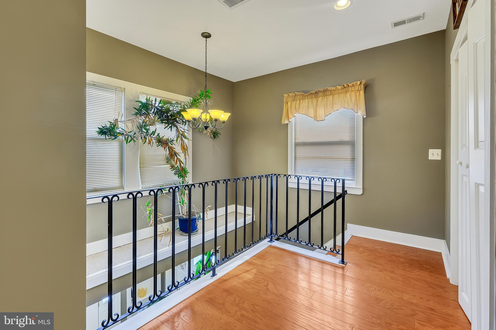 3504 Edgewood Road Baltimore, MD 21215 - Photo 43 of 60 a view of a hallway with wooden floor and a chandelier