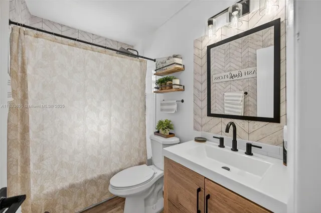 a bathroom with a sink a toilet and shower curtain