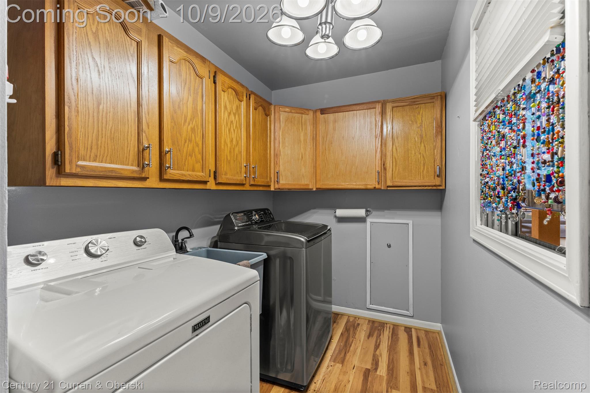43040 Willis Road Belleville, MI 48111 - Photo 33 of 65 Dedicated laundry space featuring wood-finish flooring, overhead cabinetry, and a window for natural light