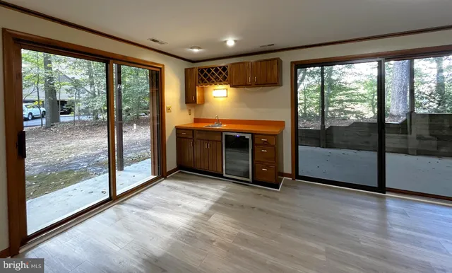 a view of an empty room with wooden floor and a floor to ceiling window