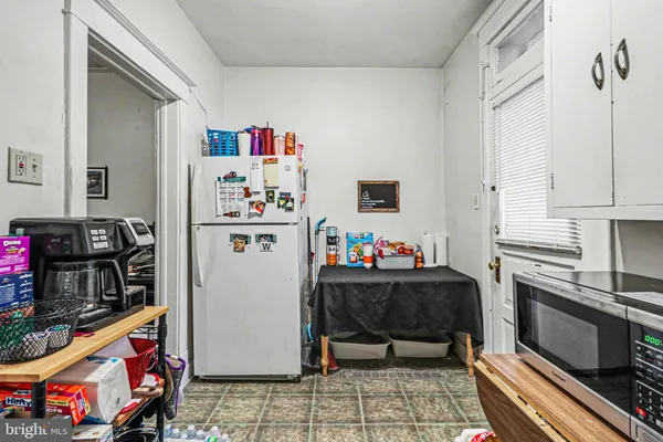 a kitchen with a refrigerator and a stove top oven