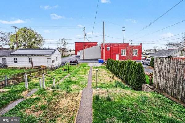 a view of a house with a yard and potted plants