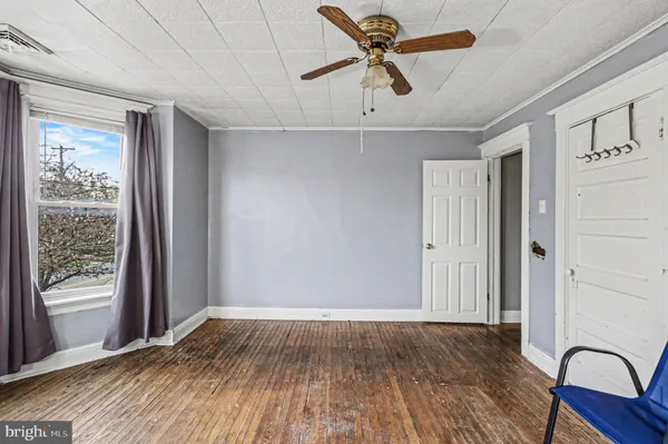 a view of room with window ceiling fan and wooden floor